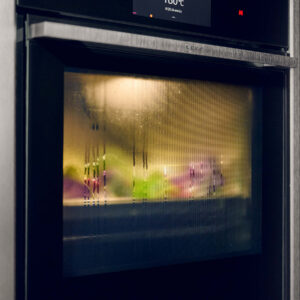 Neff Backofen bei A2 Küchen mit beschlagener Ofentür während des Garvorgangs, Dampf und verschwommene Lebensmittel im Innenraum sichtbar