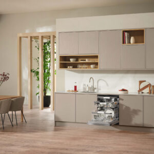 Moderne Miele Einbauküche in warmen Beigetönen mit offenen Holzregalen, integrierter Spülmaschine im geöffneten Zustand und minimalistischer Wohnküchen-Atmosphäre bei A2 Küchen