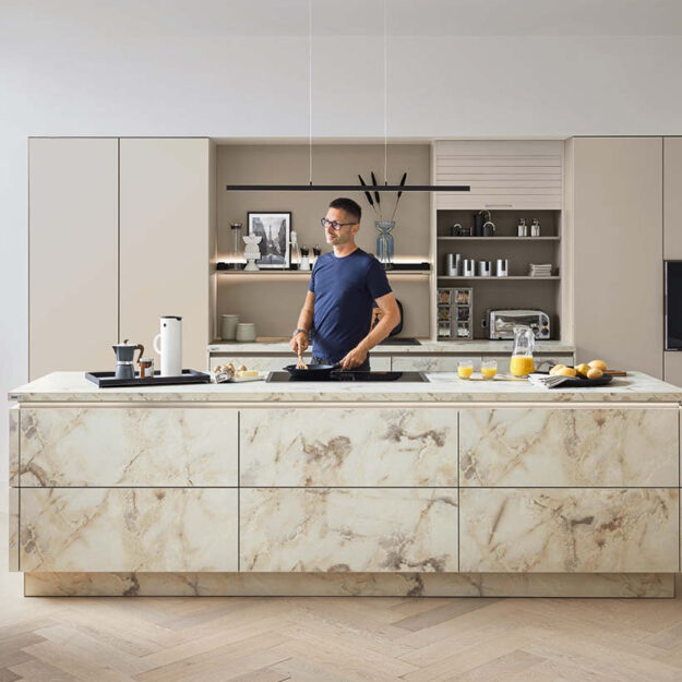 Moderne Designküche mit Kochinsel in Marmoroptik, integriertes Kochfeld und klare Linien, helle Fronten für stilvolles und funktionales Kochen