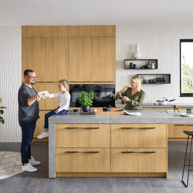 Familienfreundliche Küche in heller Holzoptik mit Kochinsel und klaren Linien, viel Stauraum und funktionale Gestaltung für gemeinsames Kochen und Alltag