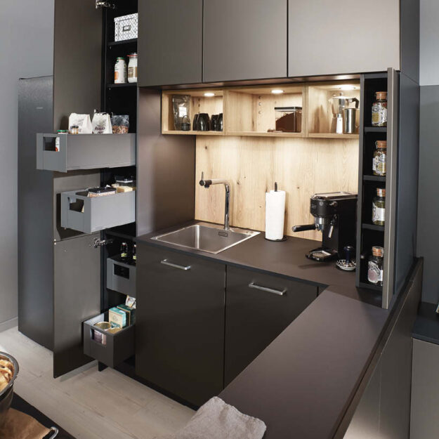 Kompakte, moderne Küche in dunklem Design mit cleveren Stauraumlösungen, ausziehbaren Schränken und integrierter Beleuchtung für maximale Funktionalität auf kleinem Raum