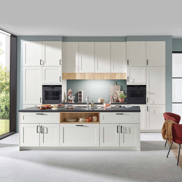 Helle Landhausküche in klassischem Weiß mit modernen Akzenten, zentraler Kochinsel und durchdachter Geräteintegration für eine freundliche und funktionale Küchenlösung